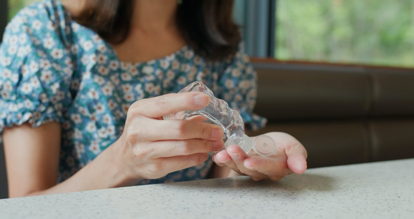 Woman use of hand sanitizer in restaurant before eating