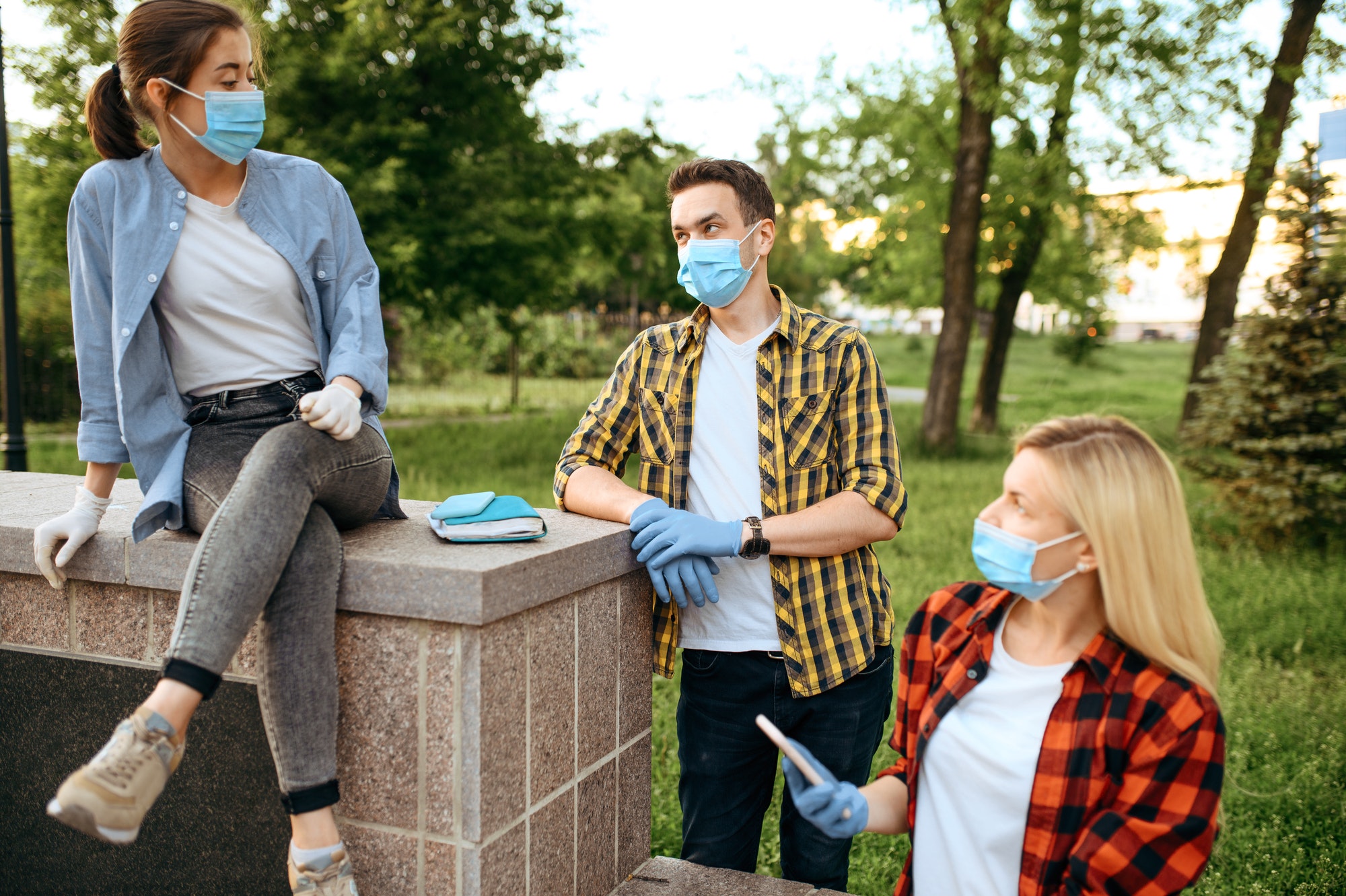 Friends in masks leisures in park, quarantine